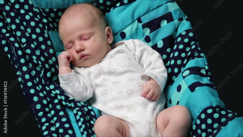 A newborn baby sleeping on a turquoise blanket A newborn baby sleeping on a turquoise blanket