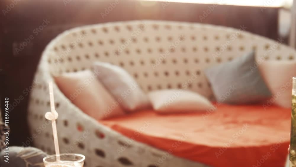 Close up view on three hands holding ice cold blue, pink and green alcoholic drinks with straws and fruit slices