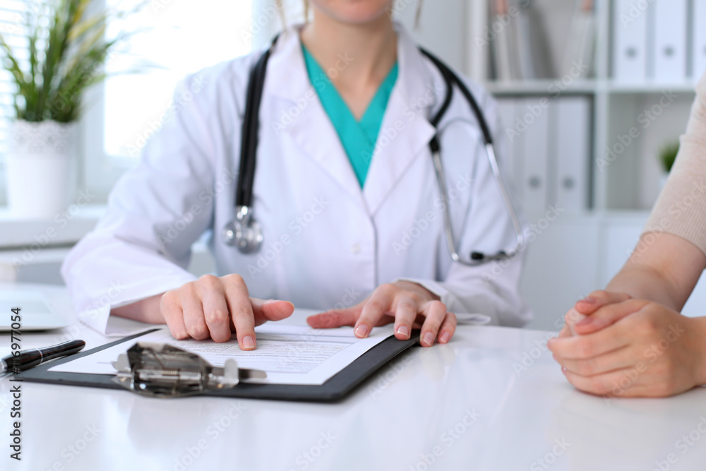 Doctor and patient are discussing something, just hands at the table Doctor and patient are discussing something, just hands at the table