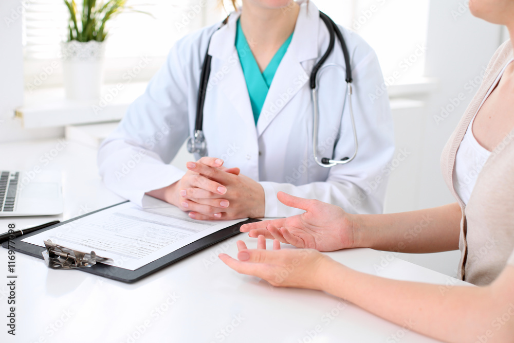 Doctor and patient are discussing something, just hands at the table Doctor and patient are discussing something, just hands at the table