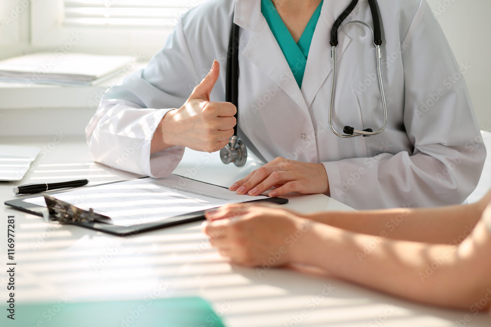 Hand of doctor reassuring her female patient and showing ok sign. Medical ethics and trust concept Hand of doctor reassuring her female patient and showing ok sign. Medical ethics and trust concept