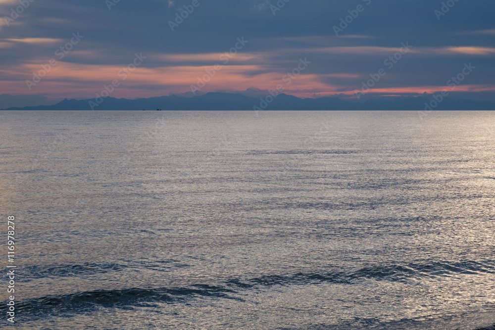 Fototapeta premium Small boat on the ocean at dusk .