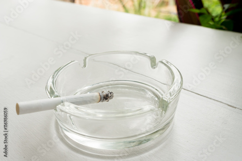 cigarette in glass ashtray