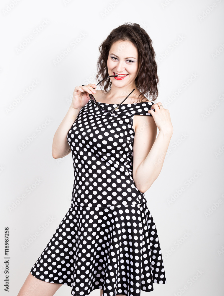 Beautiful young woman removes sun glasses, wears a dress with polka dots. expressing different emotions Beautiful young woman removes sun glasses, wears a dress with polka dots. expressing different emotions