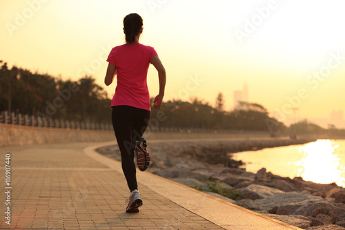 Runner athlete running at seaside. woman fitness silhouette sunrise jogging workout wellness concept.