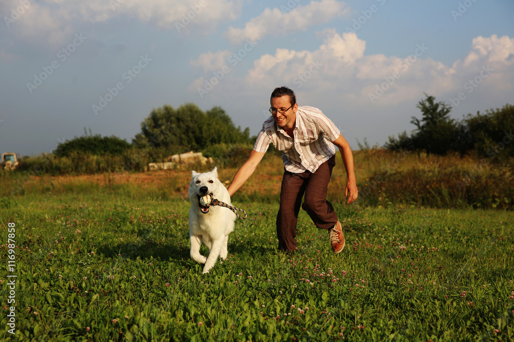 Man playing with white swiss shepherd dog Man playing with white swiss shepherd dog