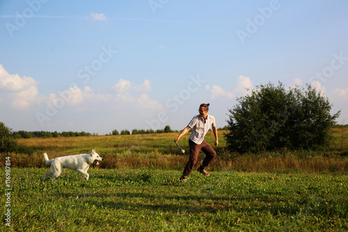 Man playing with white swiss shepherd dog © protivnica