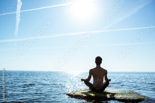 morning yoga in sunlight on sea stone