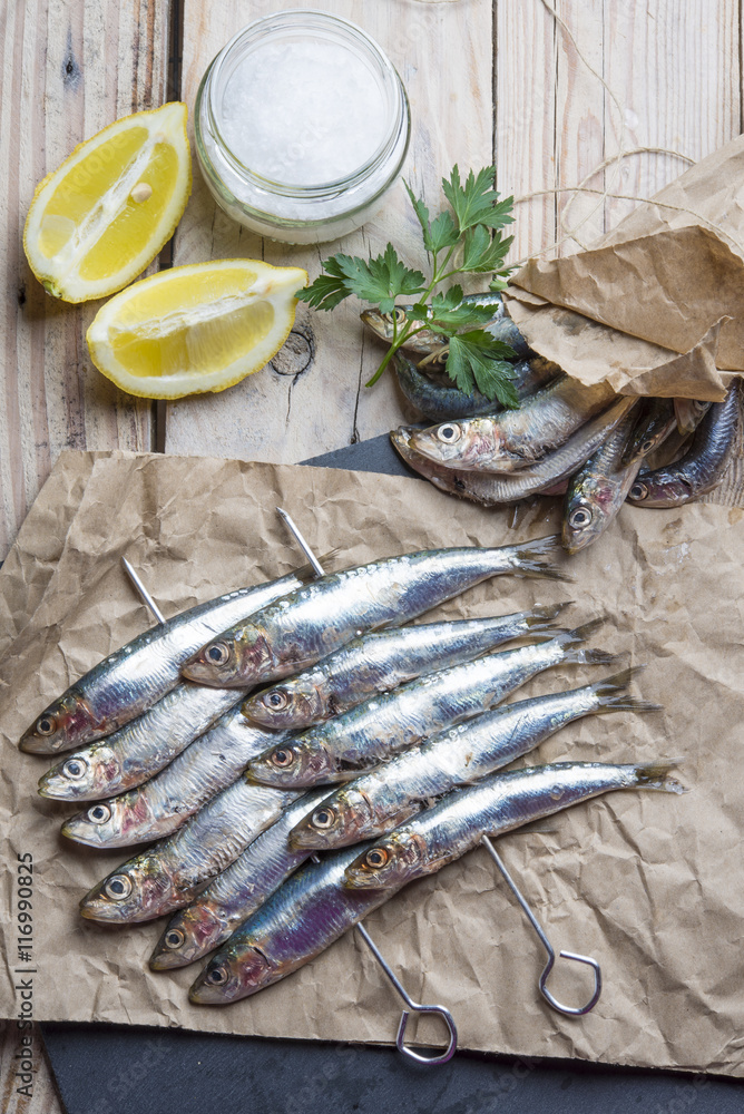 fresh sardines raw fish with coarse salt and thyme on brown pape fresh sardines raw fish with coarse salt and thyme on brown pape