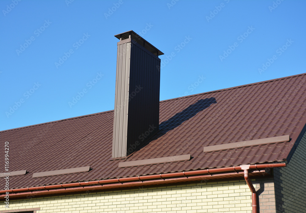 New brown metal tiled roof with plastic rain gutter system and  chimney