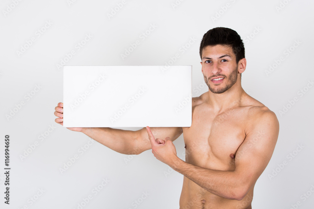 Junger, sympathischer Sportler mit freiem Oberkörper hält weißes Schild. Junger, sympathischer Sportler mit freiem Oberkörper hält weißes Schild.