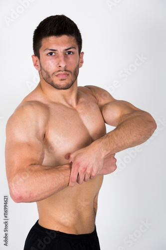 Junger sportlicher Mann zeigt seine Muskeln Oberkörperfrei
