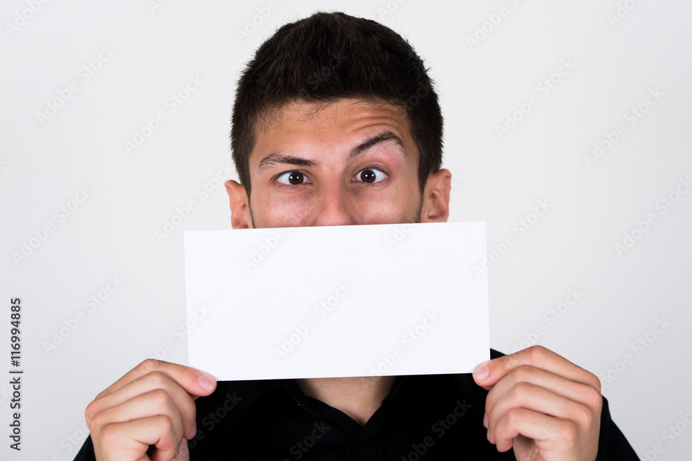 Junger Mann mit weißem Schild vor Gesicht / Mund mit Platz für Emotionen Smile Junger Mann mit weißem Schild vor Gesicht / Mund mit Platz für Emotionen Smile