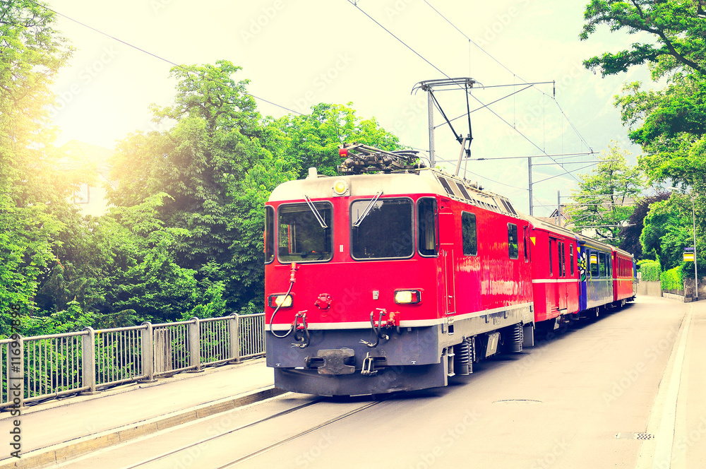 Naklejka premium Passenger train moves on the city street.