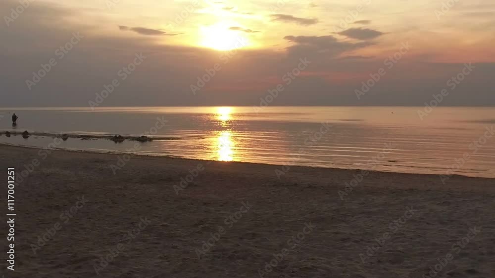 young couple walk along Summer Beach at Sunset young couple walk along Summer Beach at Sunset