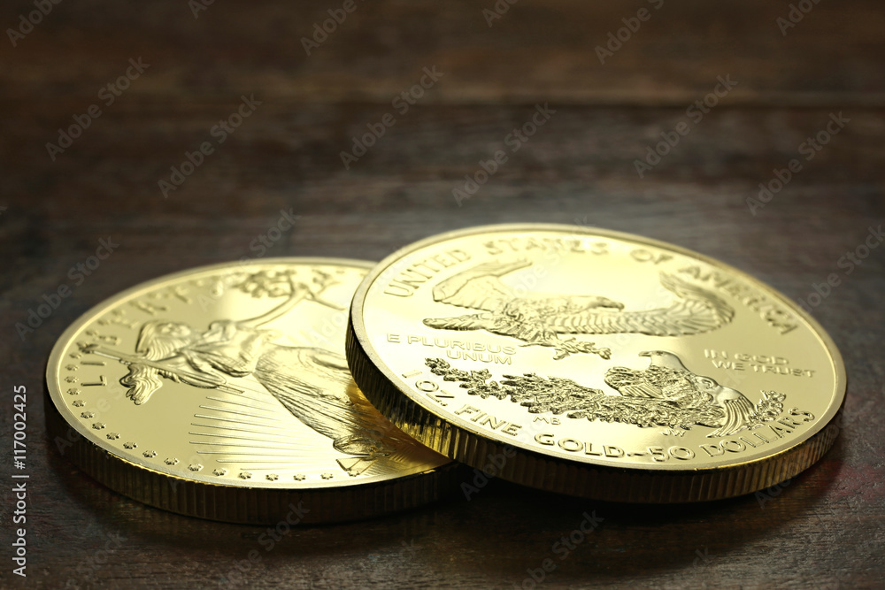 1 ounce American gold eagle bullion coins on wooden background 1 ounce American gold eagle bullion coins on wooden background