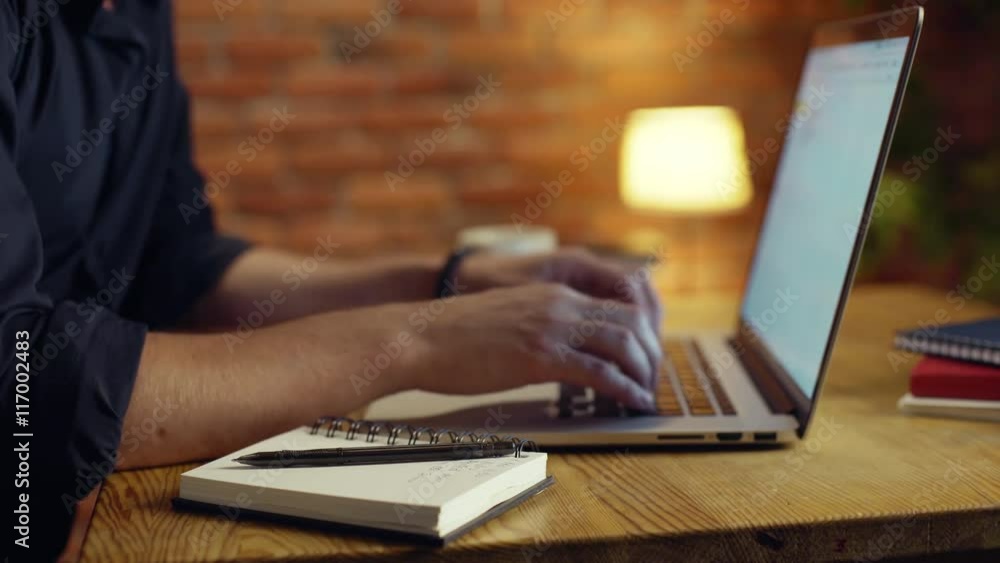 Close up of businessman working with laptop in office at night. Close up of businessman working with laptop in office at night.