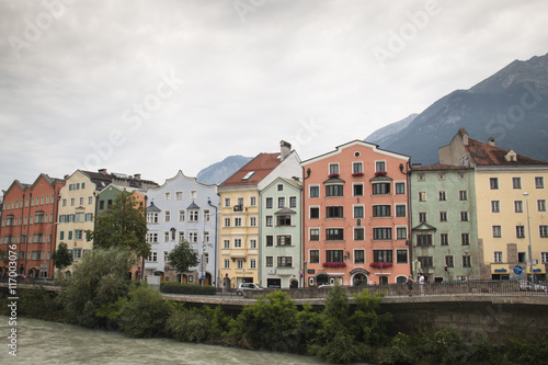 Typical Austrian houses at the embankment of the Inn river in Innsbruck, Austria with the Alps in the background 