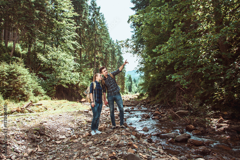A couple of tourists Hiking backpacks are viewing beautiful landscape mountain river A couple of tourists Hiking backpacks are viewing beautiful landscape mountain river