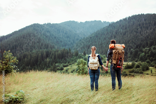 A couple of tourists in time of trip steel and admire the beautiful mountain scenery. The guy hugs the girl. The concept of love, tenderness and recreation © mikhail_kayl