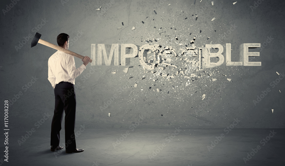Business man hitting impossible sign with hammer Business man hitting impossible sign with hammer