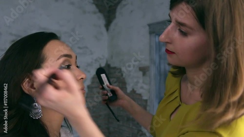 Visagist puts shadows on the eyelid, close up