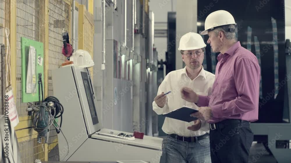Engineer asking colleague to sign up documents Engineer asking colleague to sign up documents