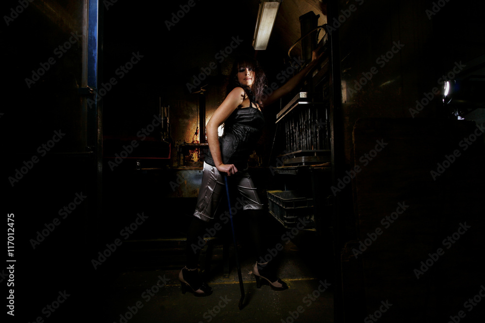 Brunette model in an abandoned workshop is posing