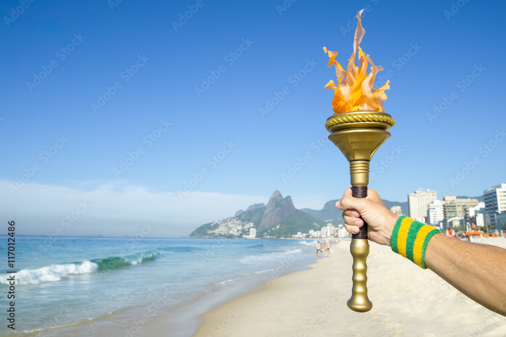 Φωτογραφία Hand of torchbearer athlete wearing Brazil colors sweatband holding sport torch