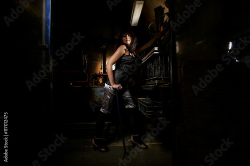 Brunette model in an abandoned workshop is posing
