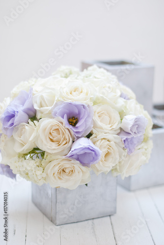 Beautiful white and blue flowers in silver vase.White background 