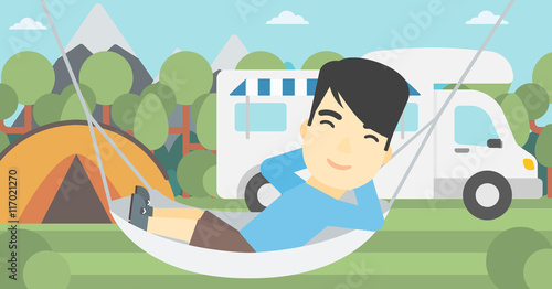 Man lying in hammock in front of motor home.