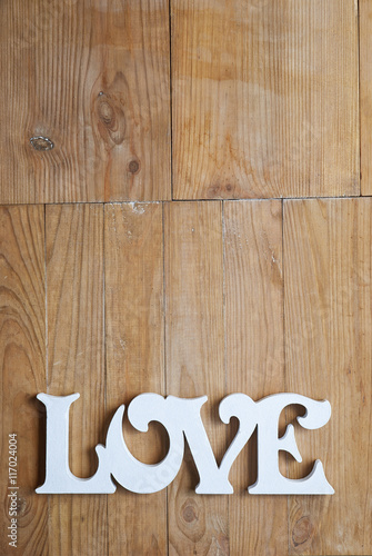 Letters forming word LOVE written on wooden background 