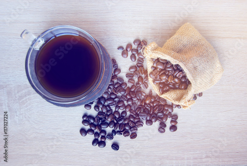  grains of coffee plant and black coffee drink on white wood bac