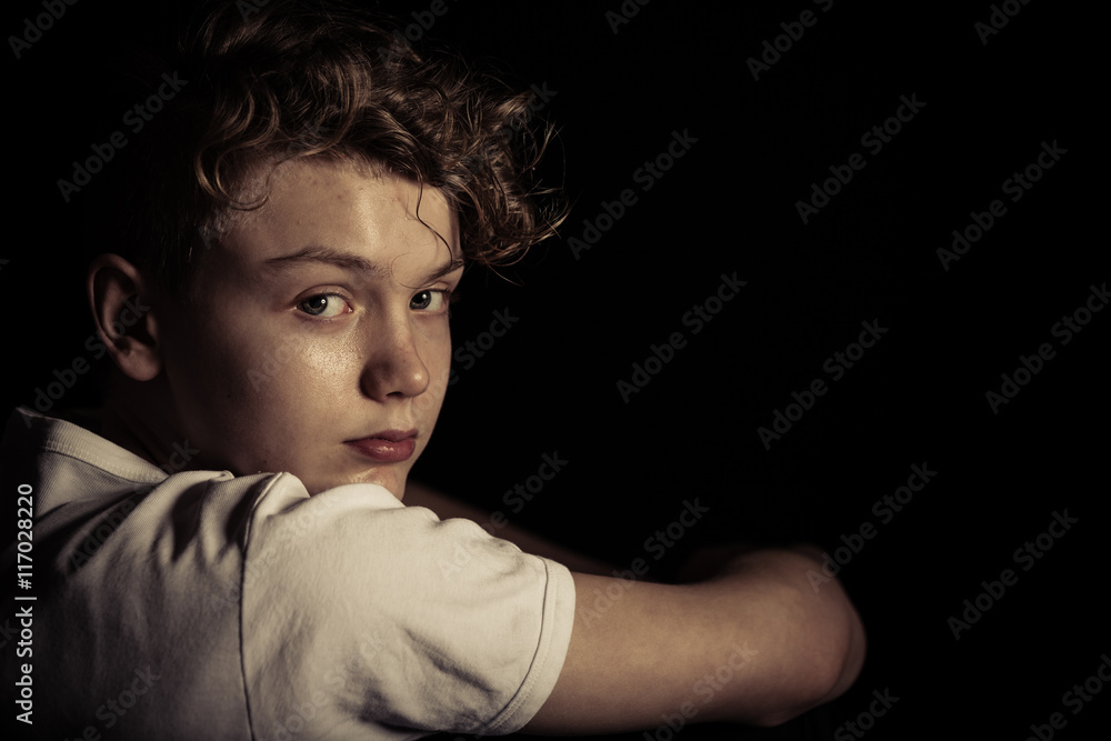 Serious Teenage Boy Looking Back Over Shoulder