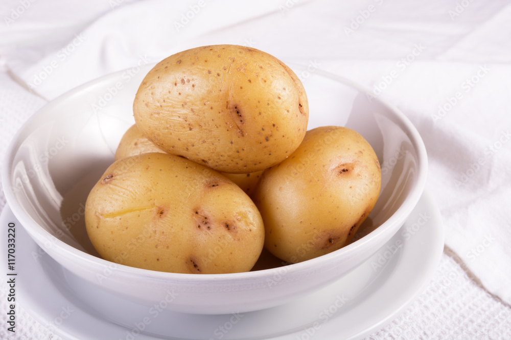 Boiled jacket potatoes served in a white bowl Boiled jacket potatoes served in a white bowl
