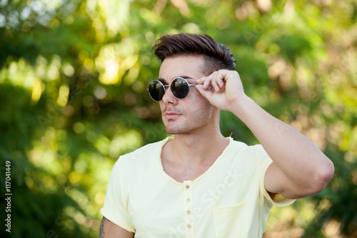 Attractive guy in the park with sunglasses