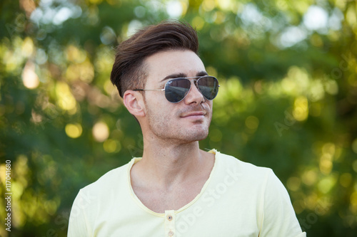 Attractive guy in the park with sunglasses