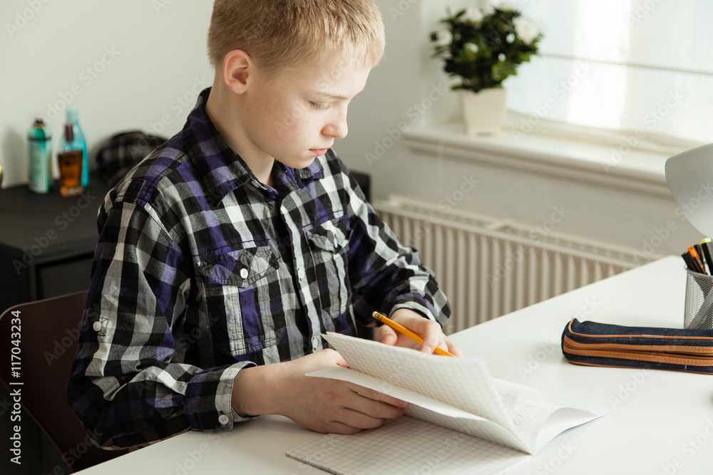 Young Teenage Boy Sitting at Desk Doing Homework Young Teenage Boy Sitting at Desk Doing Homework