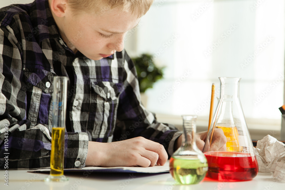 Diligent young boy doing his science homework Diligent young boy doing his science homework