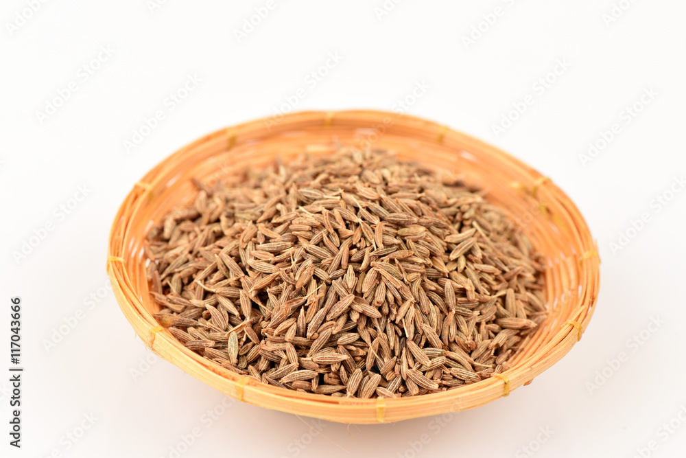 Cumin seeds, spices, medicinal properties in a basket on a white background.