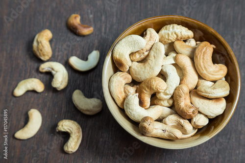 Bowl of cashew nuts from above. On wood background.