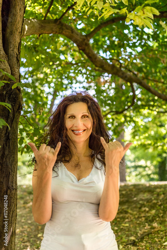 Busty classy mature woman doing welcome shaka sign