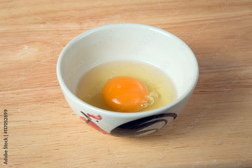 bowl of raw yolk on a wooden block bowl of raw yolk on a wooden block