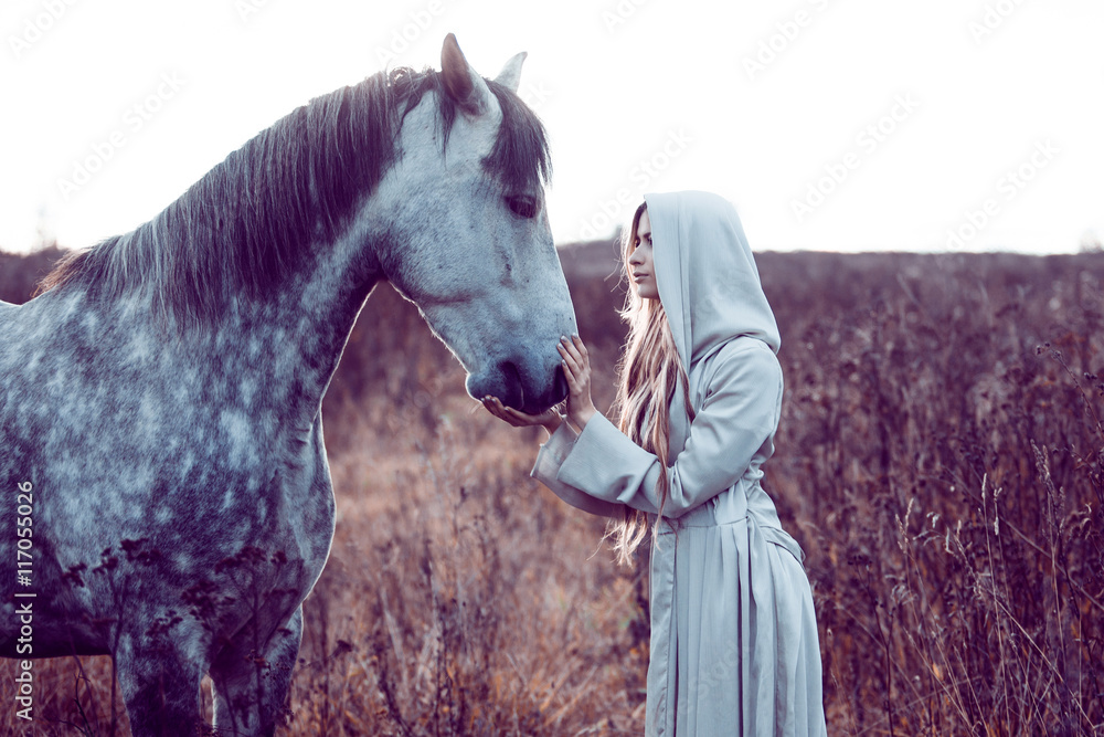 Fototapeta dziewczyna w płaszczu z kapturem z koniem, efekt tonizujący