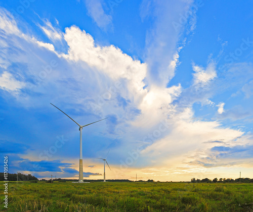 Vertorama of two windmills on rural field in the sunset. Wind turbines panorama in countryside. photo