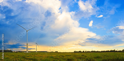 Panorama of two windmills on rural field in the sunset. Wind turbines panorama in countryside. photo