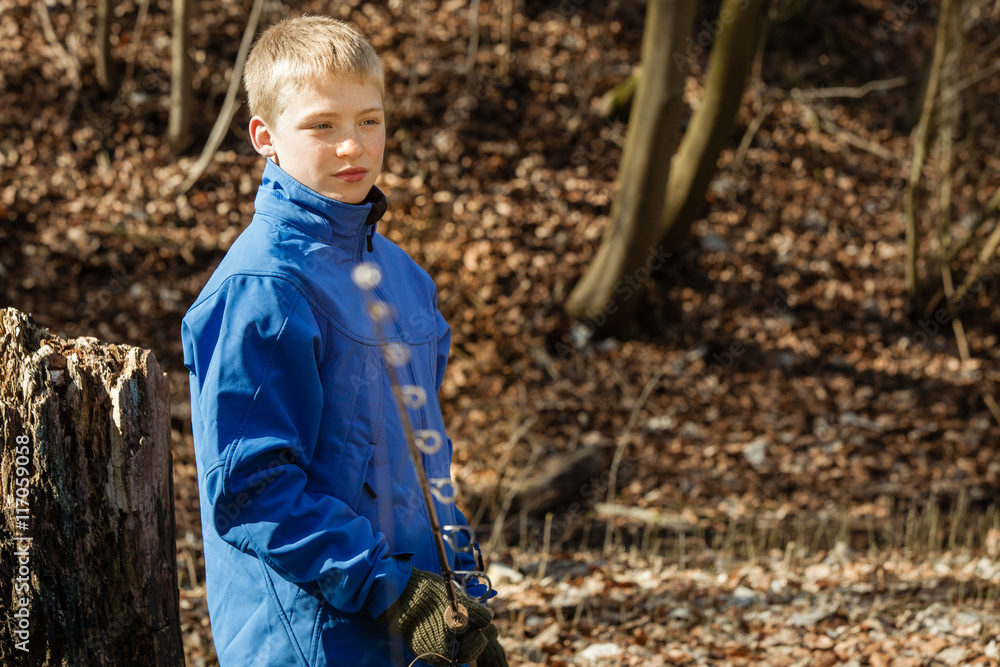 Boy with fishing rod with copy space over leaves Boy with fishing rod with copy space over leaves