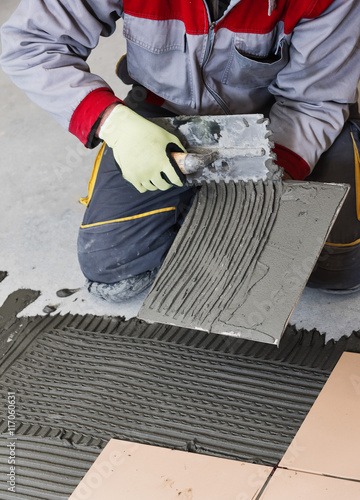 Foto Home improvement, renovation - construction worker tiler is tili