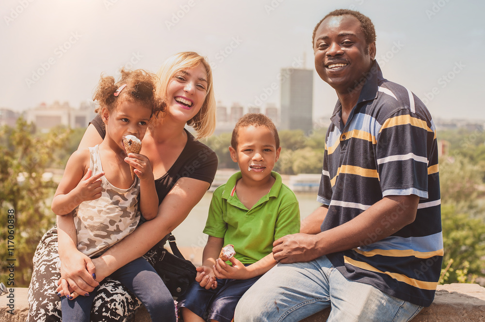Happy international family enjoying while children eat ice cream Happy international family enjoying while children eat ice cream
